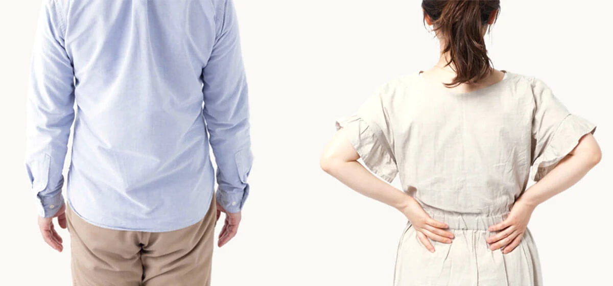腰のあたりに手をあてた女性と、隣に立つ男性の後ろ姿